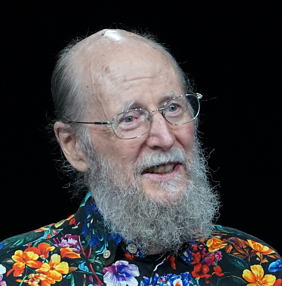 Richard S. Sutton wearing glasses and a colorful floral shirt against a black background