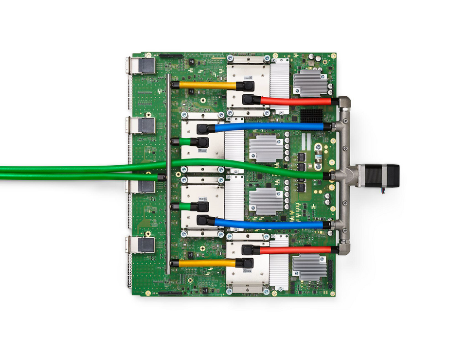 TPU v4 circuit board with four metal cooling assemblies and colored coolant connections