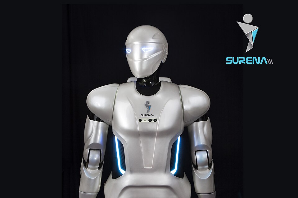 Upper body of a silver humanoid robot with a smooth helmet-like head and blue light strips against a black backdrop.
