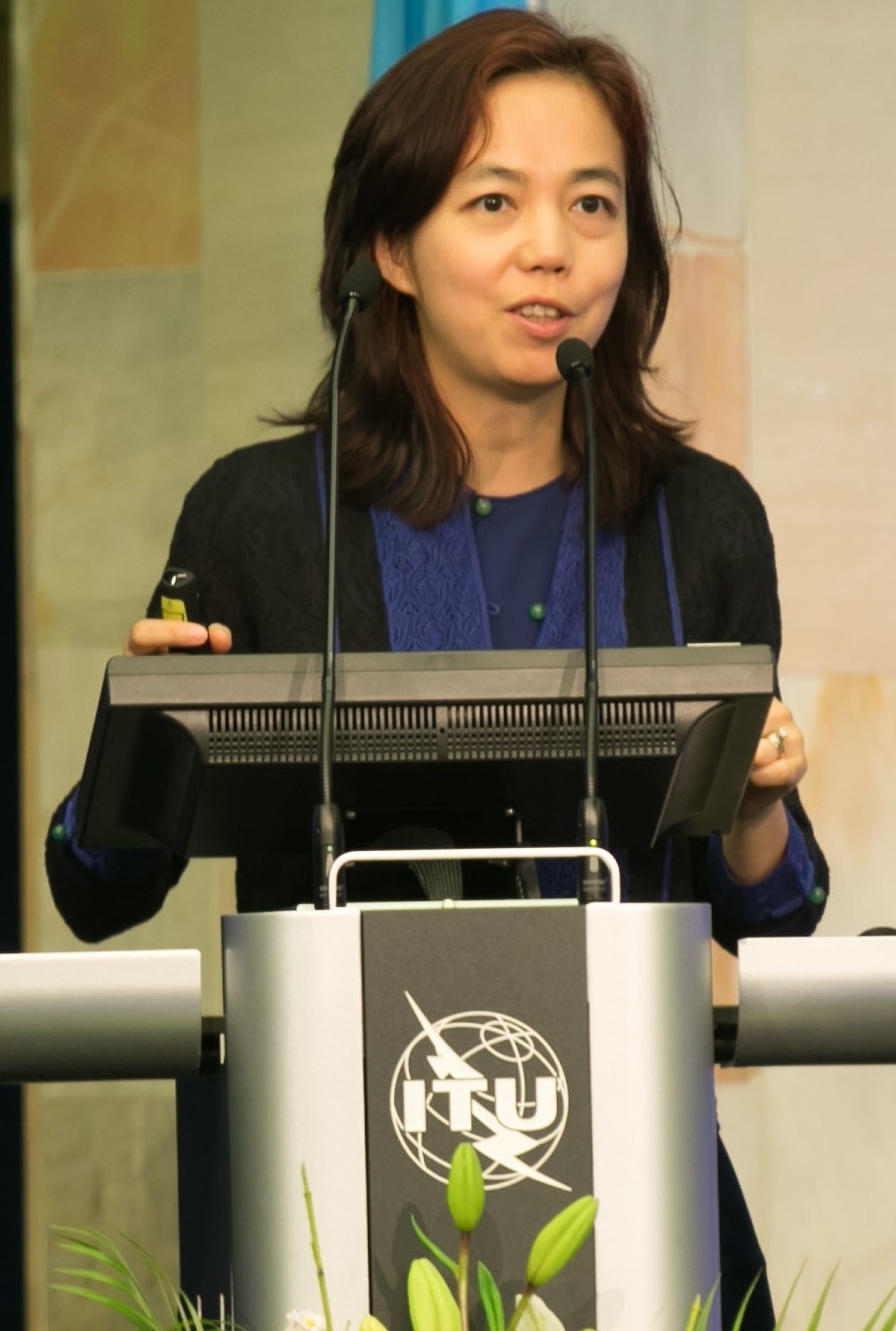 Fei-Fei Li speaking behind an ITU lectern