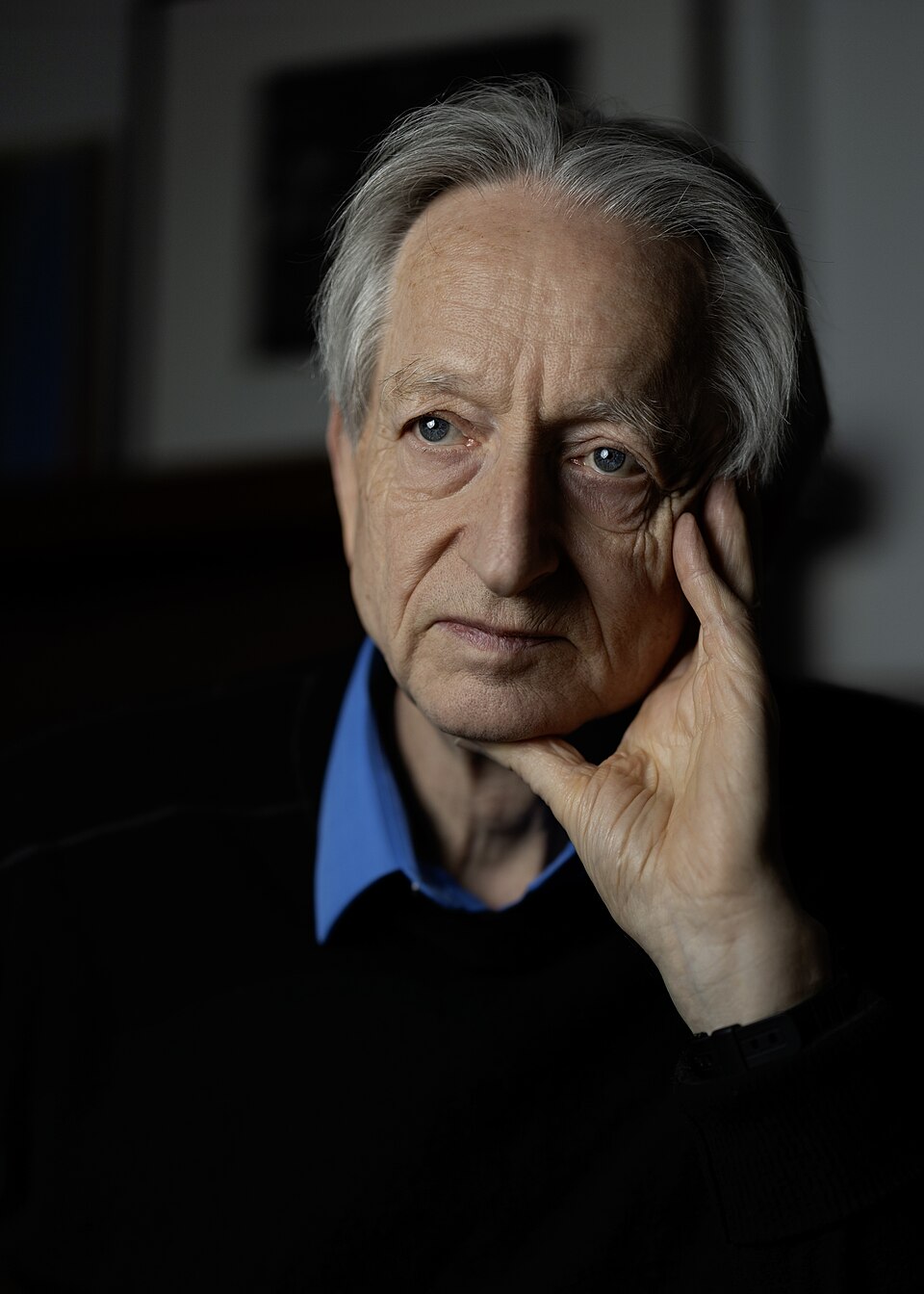 Portrait of Geoffrey Hinton resting his head on his hand