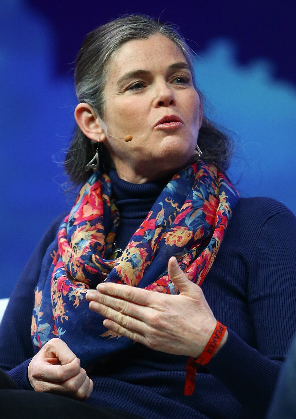 Daphne Koller speaking with a headset microphone and wearing a patterned scarf