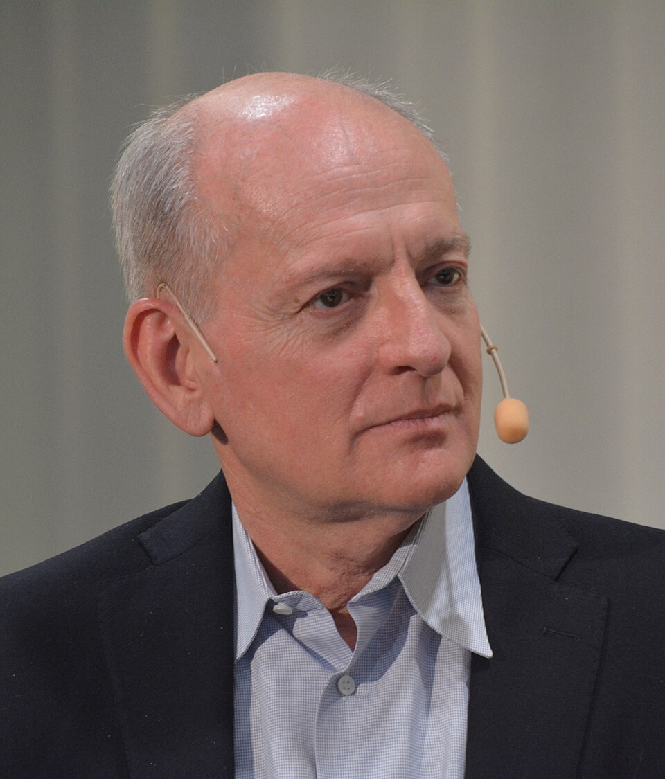 Stuart Russell wearing a dark jacket and a headset microphone