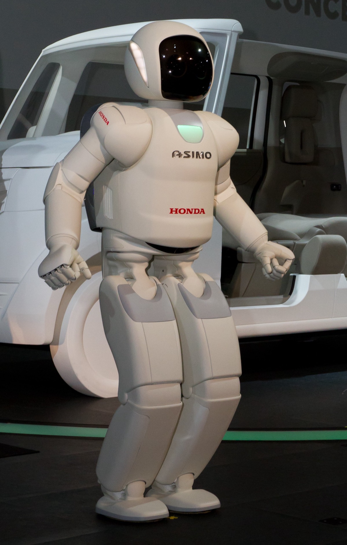 White Honda ASIMO humanoid robot standing on a stage